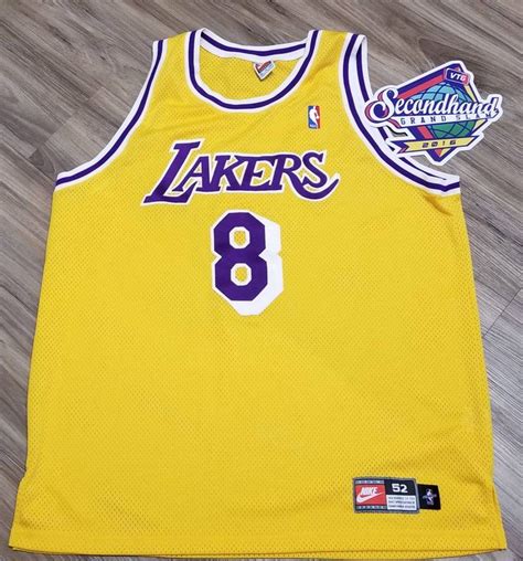 the lakers's jersey is on display in front of a wood flooring area