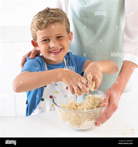 Boy rubbing butter and flour together to make cookie dough, 6 years Stock Photo - Alamy