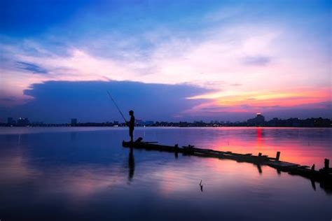 Fishing Rod Near Body of Water during Sunset · Free Stock Photo