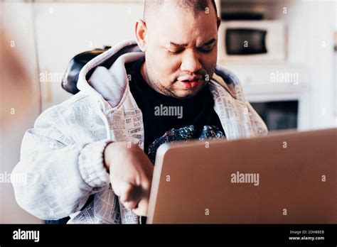 Disabled man using laptop in recording studio Stock Photo - Alamy
