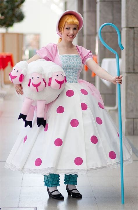 a woman in a dress and hat holding a stuffed animal