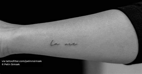 "La vie" lettering tattoo handwritten on the wrist.