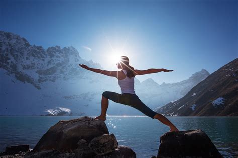 Young woman is practicing yoga at mountain lake - True Nature Abroad