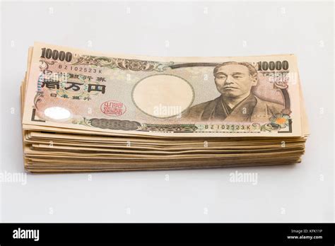 Japanese 10,000 yen banknotes in a orderly stack on plain white background Stock Photo - Alamy