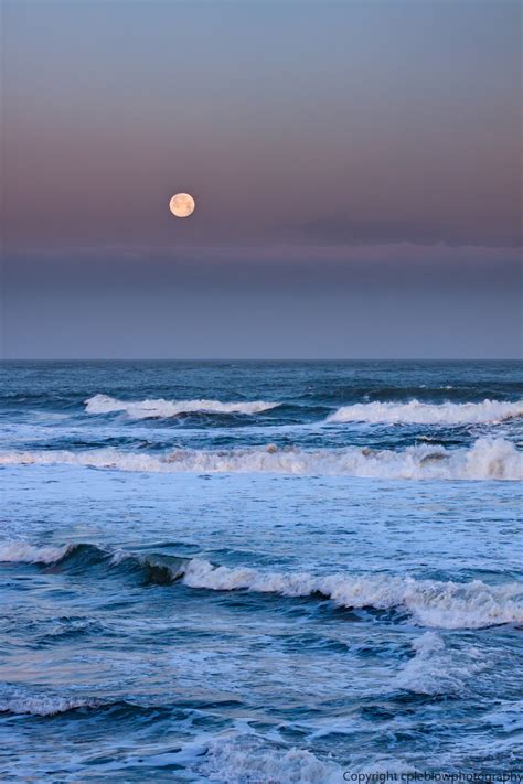 cpleblow - full moon setting off of ocean beach near sunrise,...