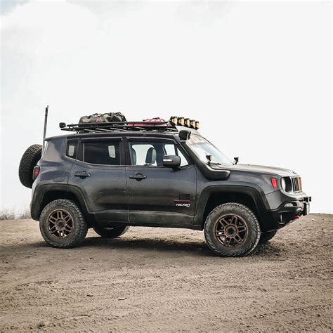 a gray jeep parked on top of a dirt field