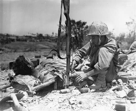 [Photo] US Navy corpsman tending to a wounded US Marine, Okinawa, Japan, May 1945; note rifle as ...