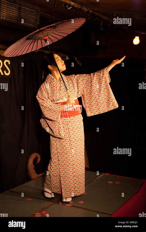 Young Japanese woman performs a traditional Japanese dance with parasol ...