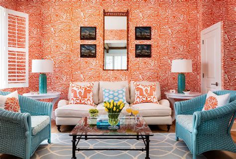 This lively living room has vibrant orange walls that commingle with ...