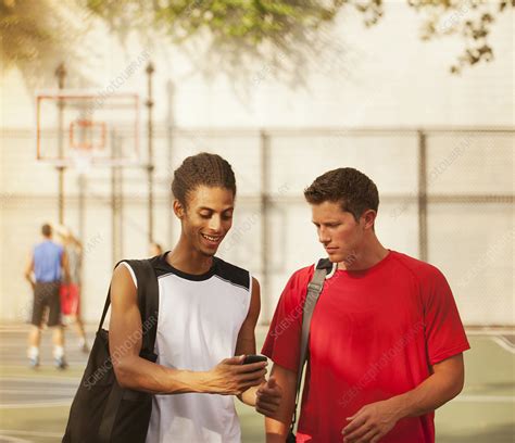 Men talking on basketball court - Stock Image - F013/6965 - Science Photo Library