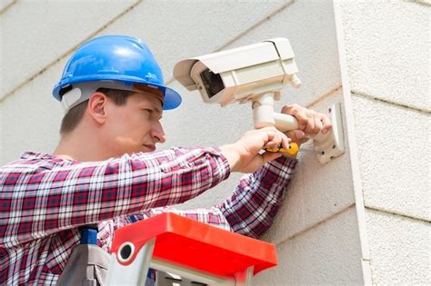 Premium Photo | Technician installing camera on wall