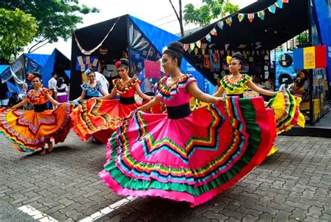 women in colorful dresses are dancing on the street