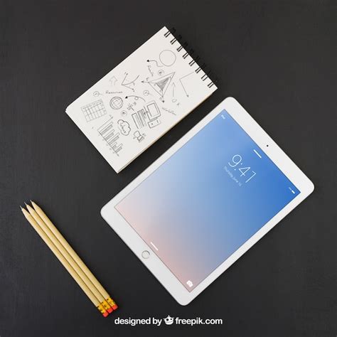 Tablet, pencils and notebook with drawing | Free PSD File