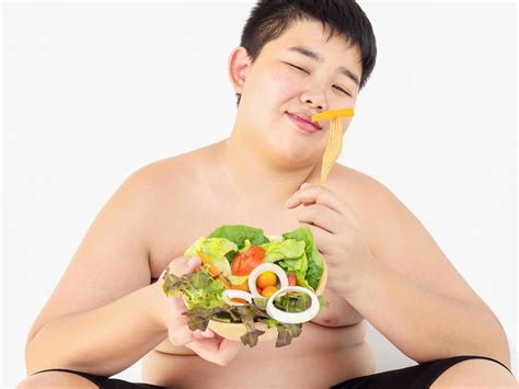 A fat boy is happily eating vegetable salad 9299347 Stock Photo at Vecteezy