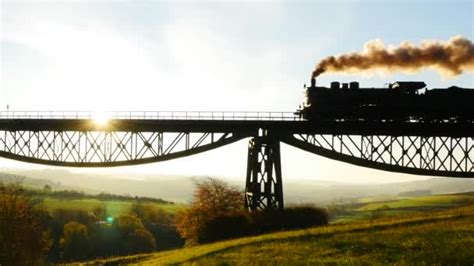 Train crossing bridge at sunset — Stock Video © stockmedia #65164225