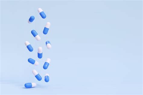 3D falling pills capsules on a blue background. Antibiotic, vitamin ...