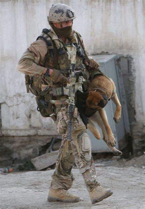 British Special Forces SBS (Special Boat Service) operator carries a wounded comrade to safety ...