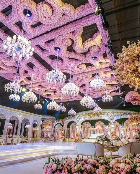 an elaborately decorated hall with chandeliers and flowers