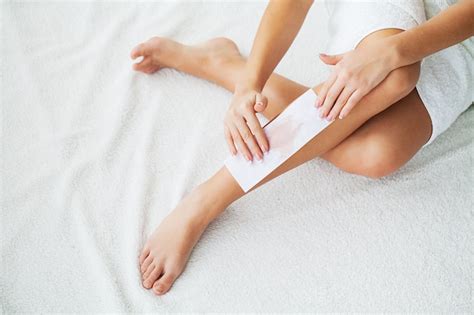 Premium Photo | Waxing. beautician waxing woman's leg in spa salon