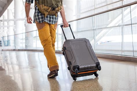 Man Pulling Luggage in an Airport Stock Photo - PixelTote