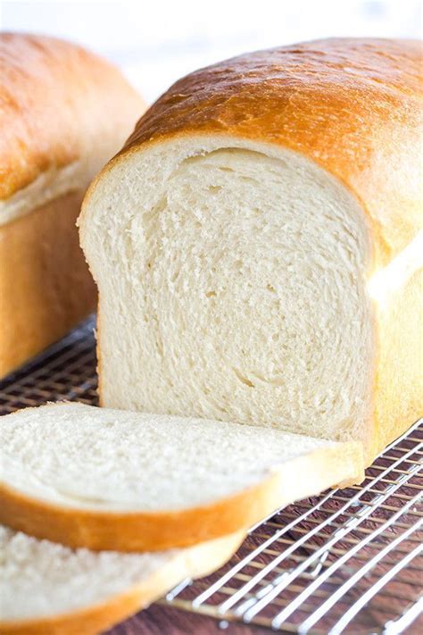 two loaves of bread sitting on top of a table next to a cooling rack