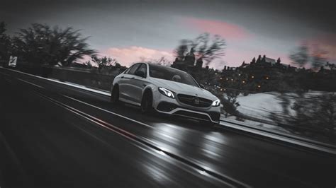 a white car driving down the road at night