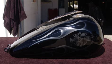 the motorcycle is shiny and black with flames on it's side panel, as well as an emblem