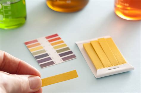 Free Stock image of Chemist holding a pH strip of litmus paper | ScienceStockPhotos.com