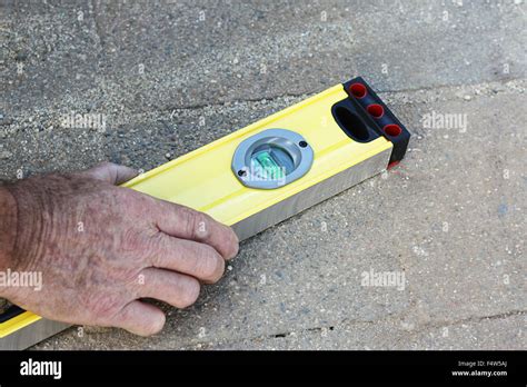 a male hand holding a level tool Stock Photo - Alamy