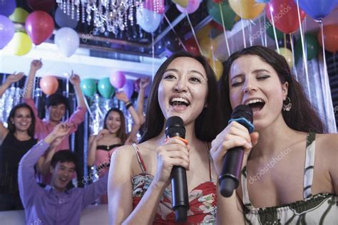 Friends singing together at karaoke — Stock Photo © XiXinXing #36655847