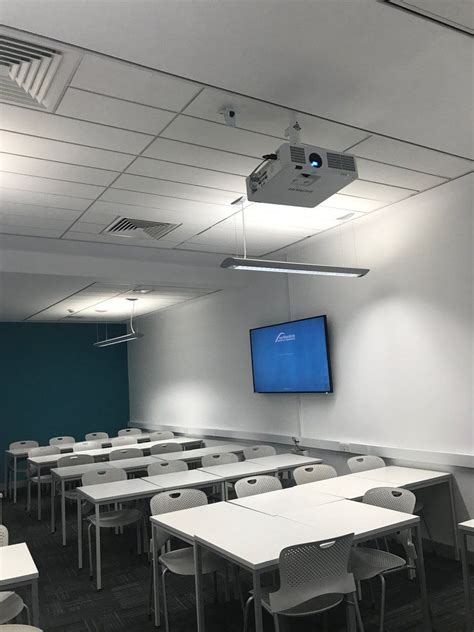 A HITACHI projector mounted to the ceiling in a classroom. | Projector ...