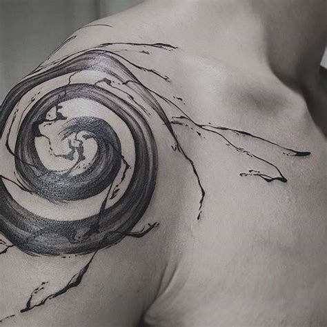 Abstract spiral tattoo on the right shoulder.