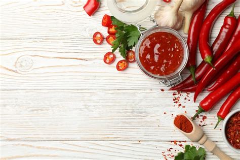 Premium Photo | Composition with red hot sauce and ingredients on wooden wall