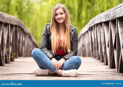 Beautiful Young Woman Sitting on a Wooden Bridge Stock Photo - Image of hand, season: 126087592