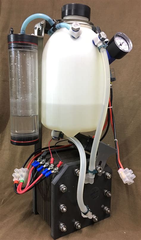 a white tank sitting on top of a black box with wires attached to the side