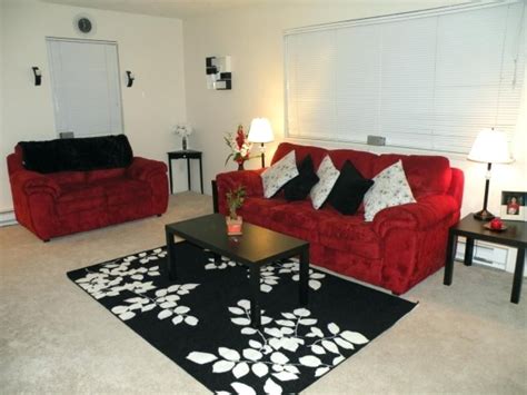 a living room with red couches and black rug