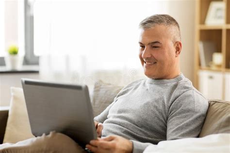 Man with Laptop Computer Sitting on Sofa at Home Stock Photo - Image of ...