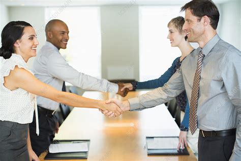 Business people shaking hands in meeting - Stock Image - F014/3065 - Science Photo Library