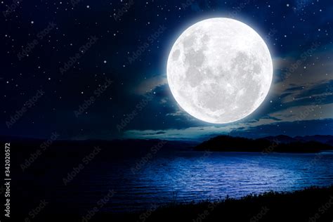 Bright full moon over lake at night. Stock Photo | Adobe Stock