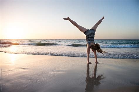 "Teenage Girl Doing A Cartwheel At The Beach At Sunset" by Stocksy Contributor "Angela Lumsden ...