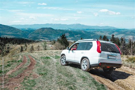 car travel concept suv driving by country road leading to the mountains Stock Photo | Adobe Stock