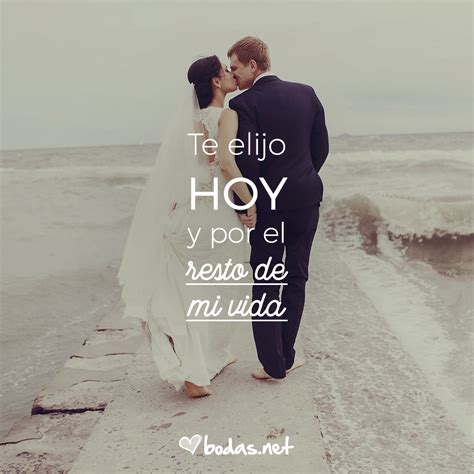 a bride and groom kissing on the beach with an ocean in the backgroud