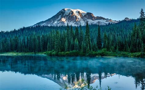 Snow-capped mountain surrounded with trees near body of water, nature ...