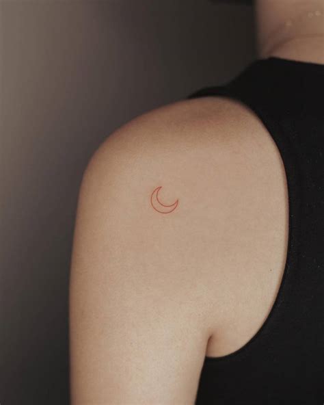 Minimalist red crescent moon tattoo located on the