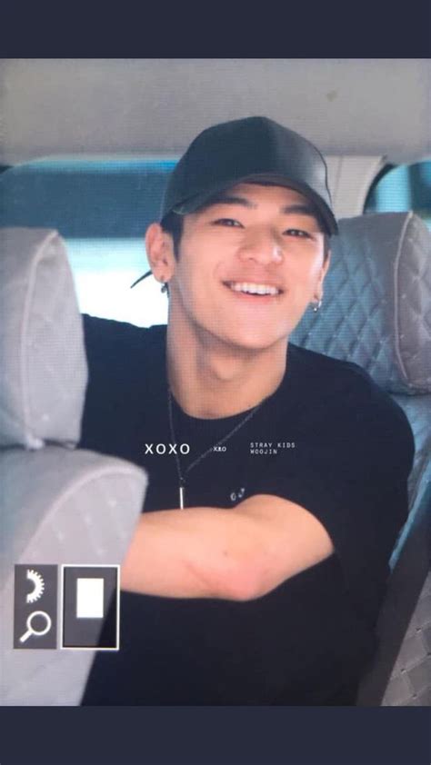 a man sitting in the back seat of a car wearing a black shirt and hat