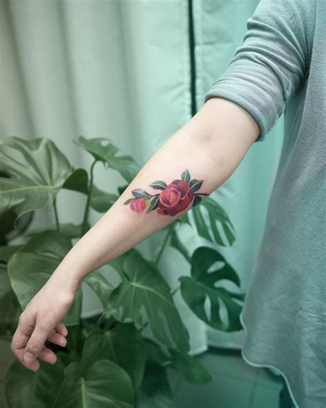 Red Camellia flower tattoo by Mavka Leesova inked on the right forearm ...