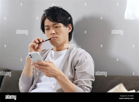 Japanese man brushing teeth on the sofa Stock Photo - Alamy