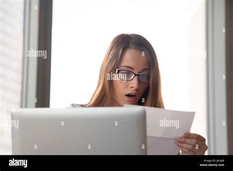 Surprised young businesswoman reading letter Stock Photo - Alamy