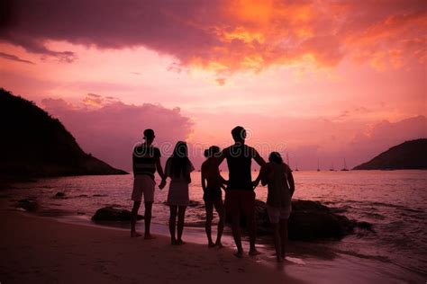 Friends on beach at sunset stock image. Image of group - 147381973