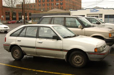 OLD PARKED CARS.: 1988 Mercury Tracer 5-Door Hatchback.